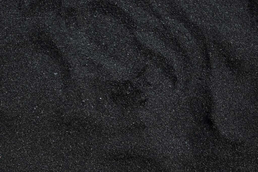 Close-up of black sand texture from Waimea Beach in Hawaii. Ideal for backgrounds.